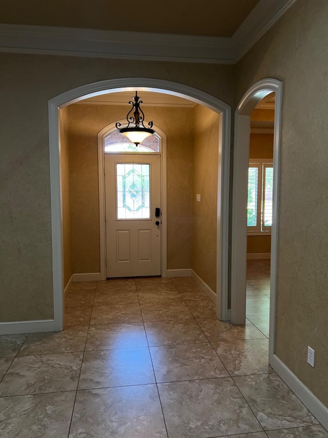 foyer featuring ornamental molding and a healthy amount of sunlight