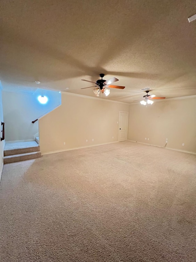 carpeted spare room featuring ceiling fan, ornamental molding, and a textured ceiling