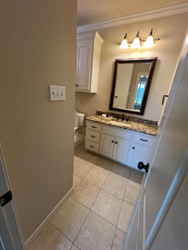 bathroom with vanity, ornamental molding, tile patterned floors, and toilet