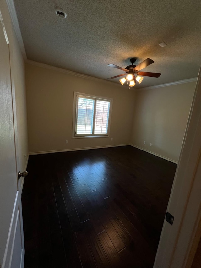 spare room featuring dark hardwood / wood-style flooring, a textured ceiling, ornamental molding, and ceiling fan