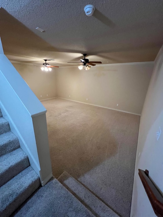 living room featuring ceiling fan, carpet floors, and a textured ceiling