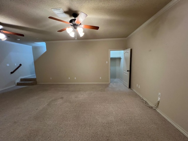 unfurnished room featuring ornamental molding, light colored carpet, a textured ceiling, and ceiling fan