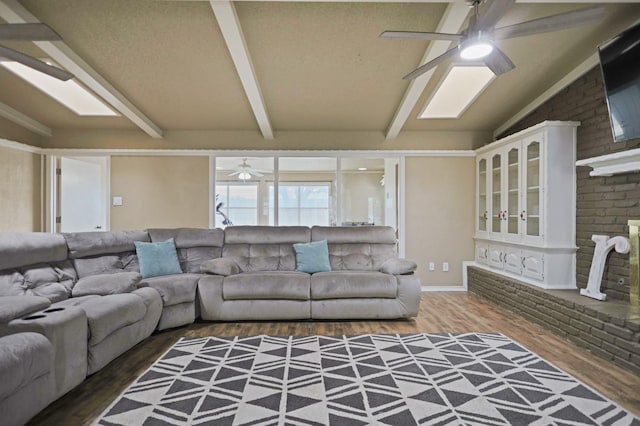 living room featuring hardwood / wood-style floors, a fireplace, lofted ceiling with beams, and ceiling fan