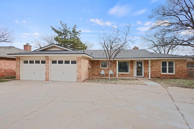 ranch-style home featuring central AC and a garage