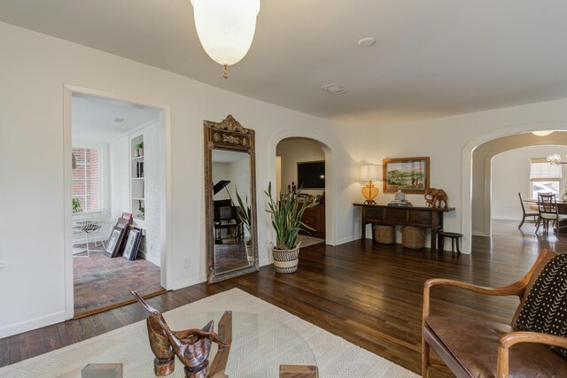 living room featuring dark wood-type flooring and ceiling fan