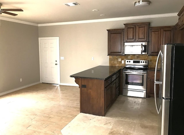 kitchen featuring crown molding, appliances with stainless steel finishes, kitchen peninsula, and dark stone counters