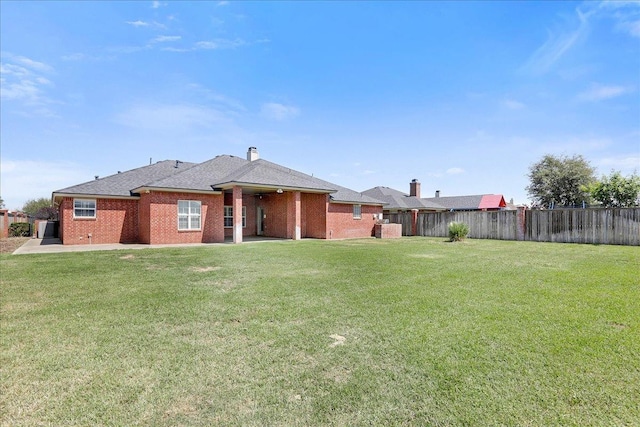 rear view of property with a lawn and a patio area