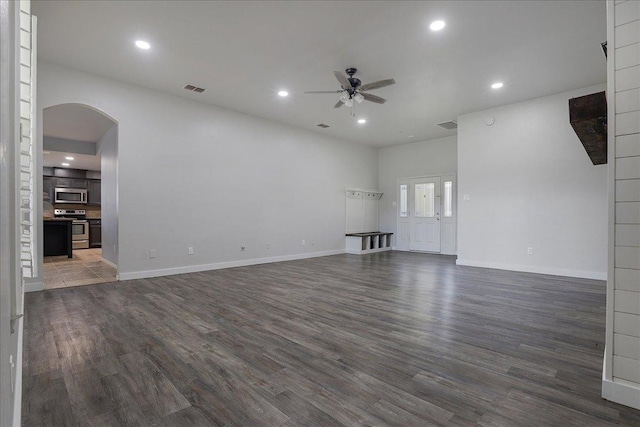 unfurnished living room with dark hardwood / wood-style floors and ceiling fan