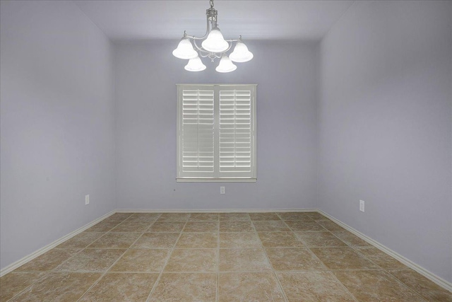 spare room featuring a notable chandelier and tile patterned floors