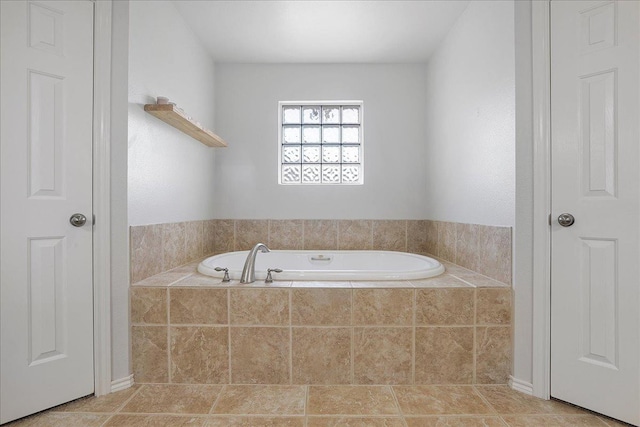 bathroom with tile patterned flooring and a relaxing tiled tub