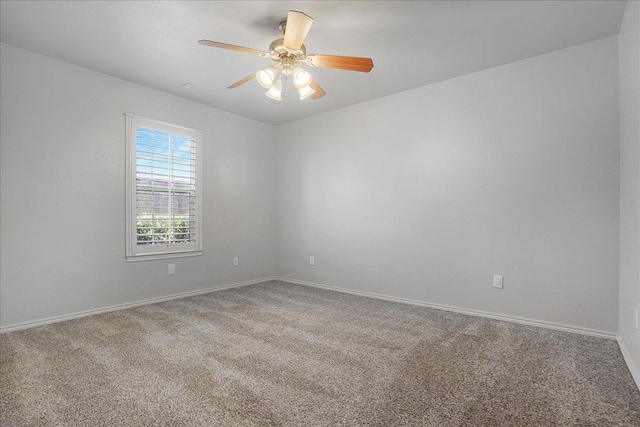 carpeted spare room with ceiling fan