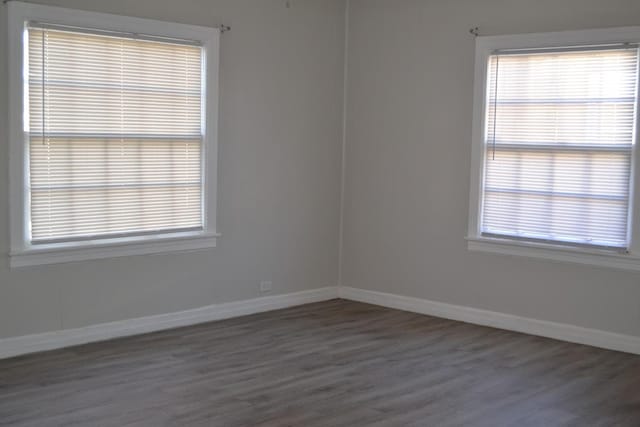 spare room featuring dark hardwood / wood-style flooring and a wealth of natural light