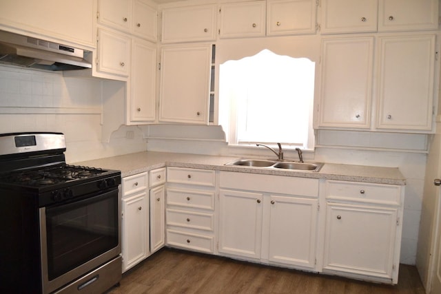 kitchen with sink, dark wood-type flooring, tasteful backsplash, gas stove, and white cabinets