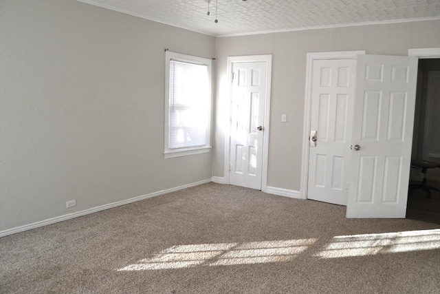 unfurnished bedroom with crown molding and dark carpet