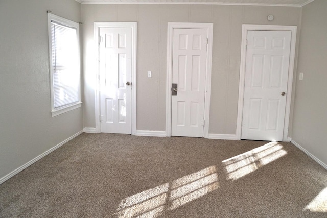 unfurnished bedroom with multiple windows, crown molding, and carpet floors