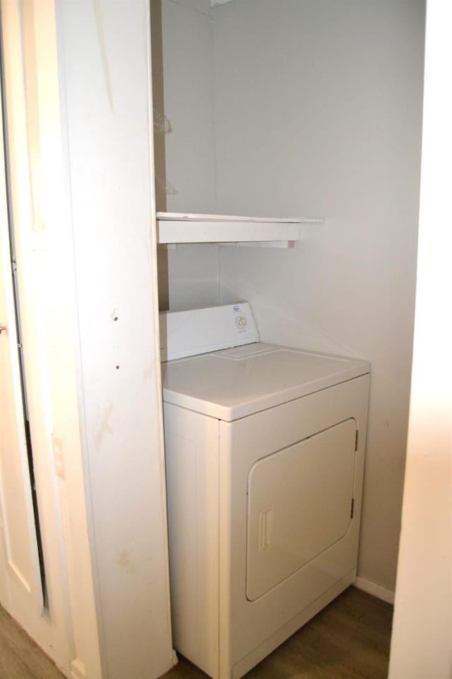 clothes washing area with wood-type flooring and washer / dryer