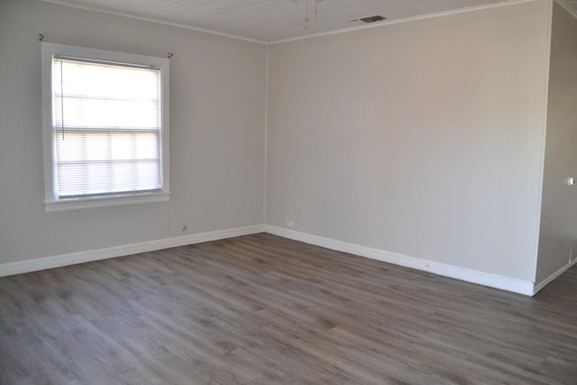 empty room with dark wood-type flooring and ornamental molding