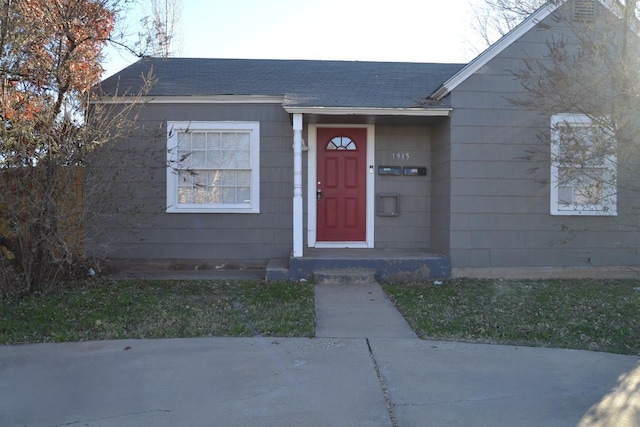 view of exterior entry with a lawn