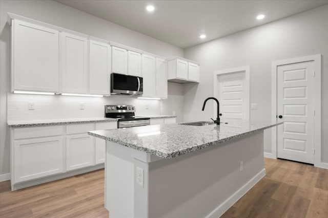 kitchen with a kitchen island with sink, sink, white cabinetry, and stainless steel appliances