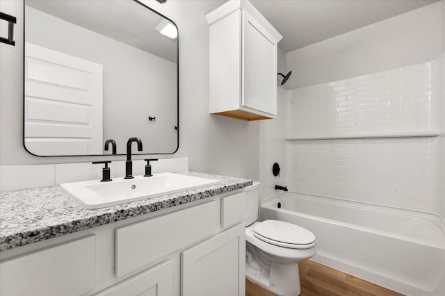 full bathroom featuring vanity, toilet, tiled shower / bath combo, and hardwood / wood-style floors