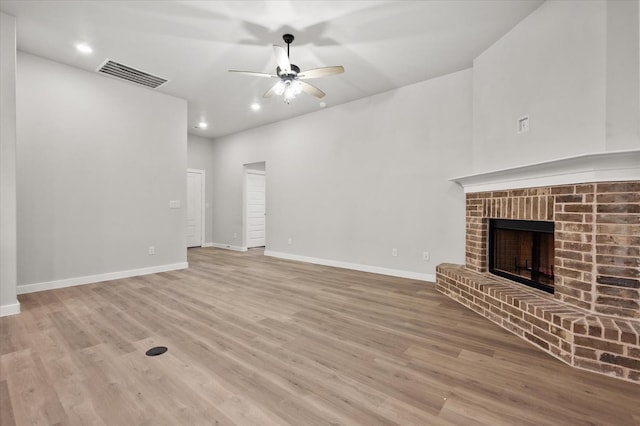 unfurnished living room with light hardwood / wood-style flooring, a fireplace, and ceiling fan