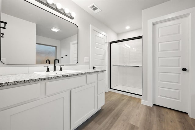 bathroom with vanity, hardwood / wood-style floors, and walk in shower