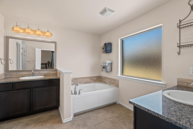 bathroom with vanity, tile patterned flooring, and a bathtub