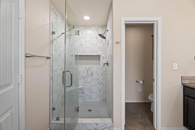 bathroom featuring vanity, tile patterned flooring, a shower with shower door, and toilet