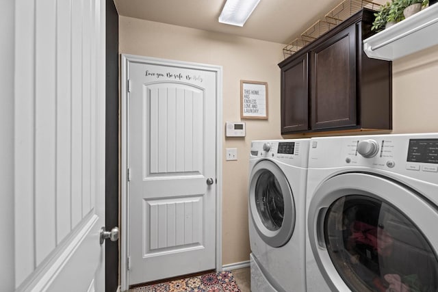 clothes washing area featuring cabinets and washing machine and clothes dryer