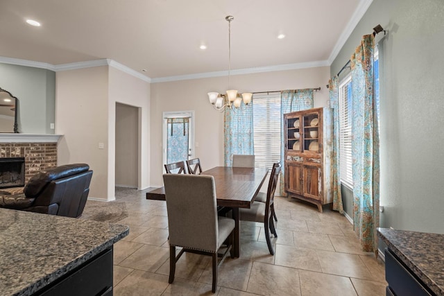 dining space with a brick fireplace, a notable chandelier, ornamental molding, and light tile patterned floors