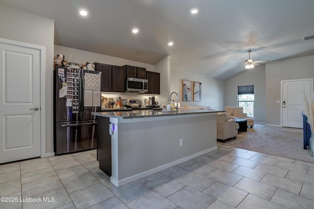 7511 31st St, Lubbock, TX 79407 - kitchen featuring stainless steel appliances, vaulted ceiling, a ceiling fan, dark brown cabinets, and dark stone counters
