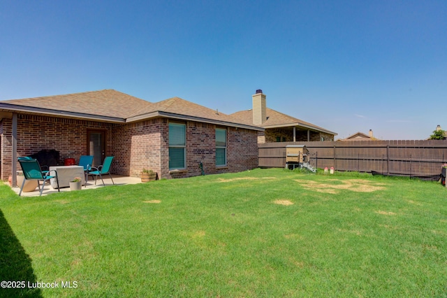 7511 31st St, Lubbock, TX 79407 - back of property with a fenced backyard, a patio area, a chimney, brick siding, and roof with shingles