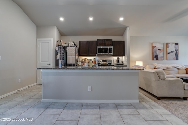 7511 31st St, Lubbock, TX 79407 - kitchen featuring stainless steel appliances, open floor plan, dark brown cabinets, and dark stone countertops