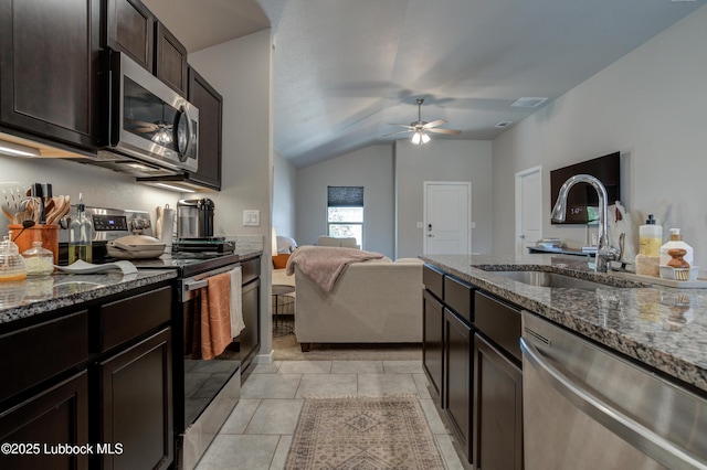 7511 31st St, Lubbock, TX 79407 - kitchen featuring stainless steel appliances, lofted ceiling, dark stone countertops, a ceiling fan, and dark brown cabinetry