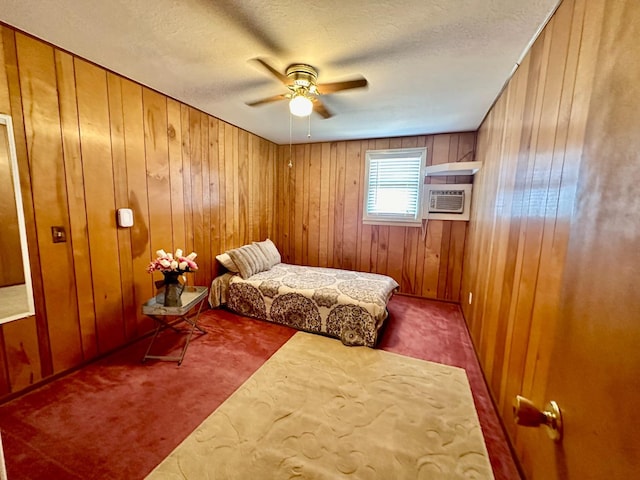 carpeted bedroom featuring ceiling fan, wooden walls, and a textured ceiling