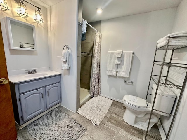 bathroom with toilet, vanity, and walk in shower