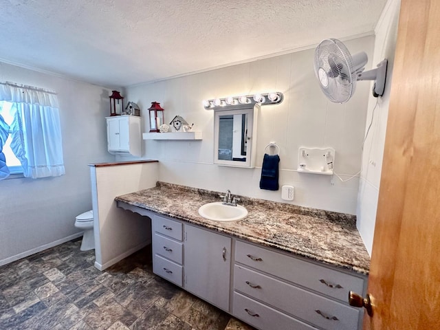 bathroom with vanity, a textured ceiling, and toilet