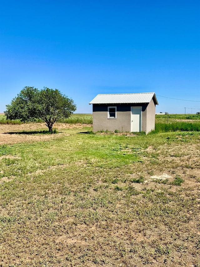 view of yard with an outbuilding and a rural view