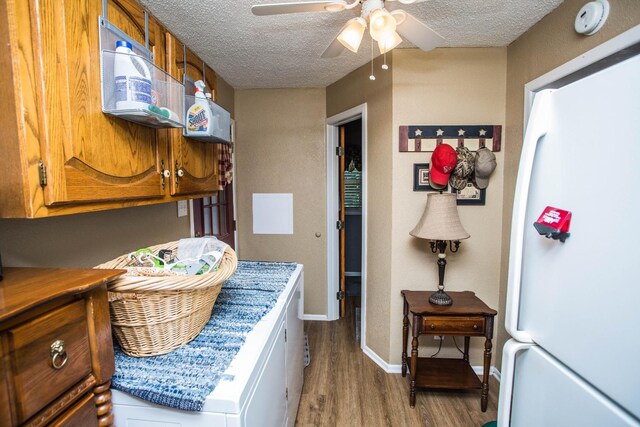 interior space with ceiling fan, wood-type flooring, a textured ceiling, and white fridge