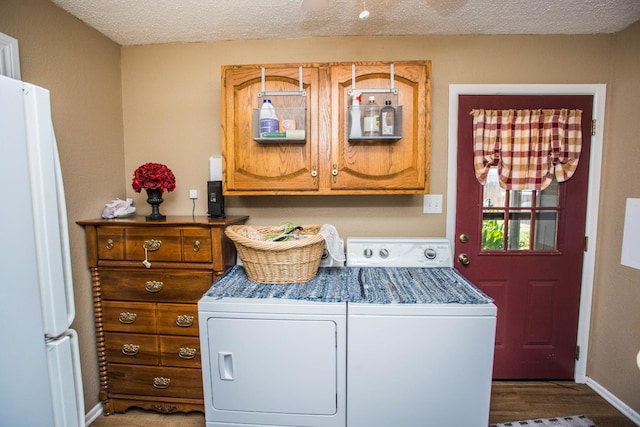 laundry area featuring wood-type flooring, washer and dryer, and a textured ceiling