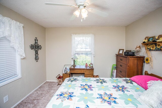 bedroom featuring ceiling fan, light colored carpet, and a textured ceiling