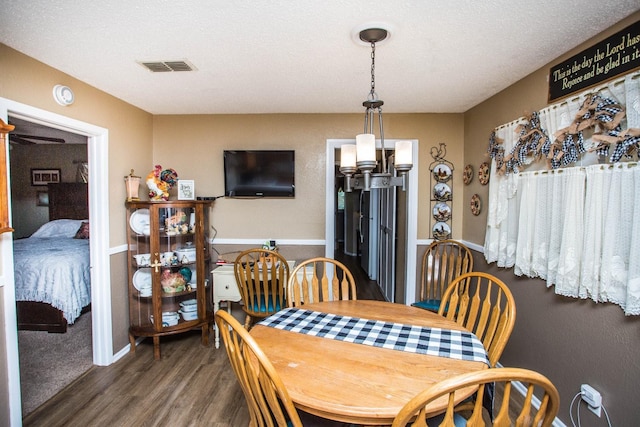 dining space with a textured ceiling and dark hardwood / wood-style flooring