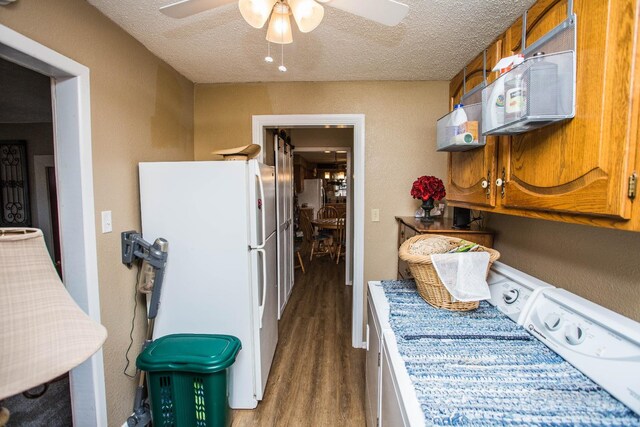 kitchen featuring ceiling fan, white fridge, dark wood-type flooring, and a textured ceiling