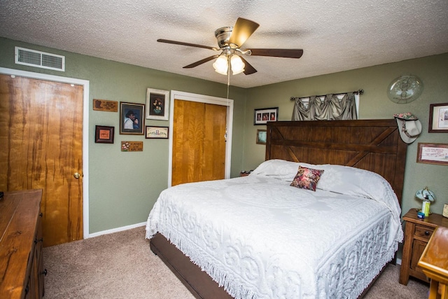 bedroom featuring ceiling fan, a closet, carpet floors, and a textured ceiling