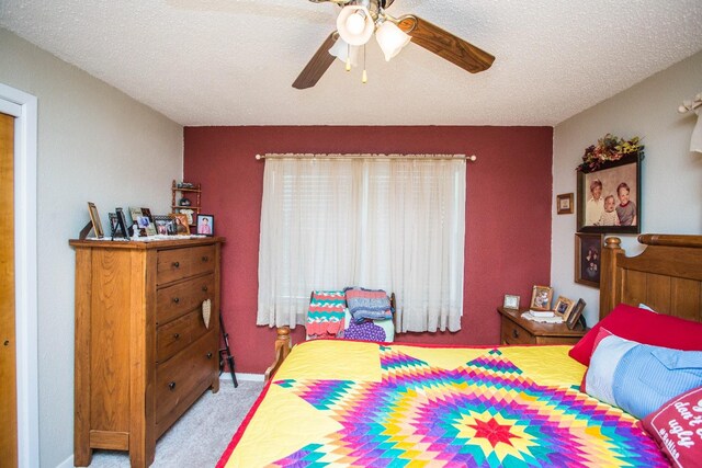 carpeted bedroom with ceiling fan and a textured ceiling