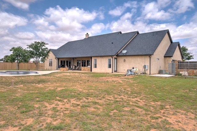 rear view of house featuring a yard, a fenced in pool, a patio, and central air condition unit