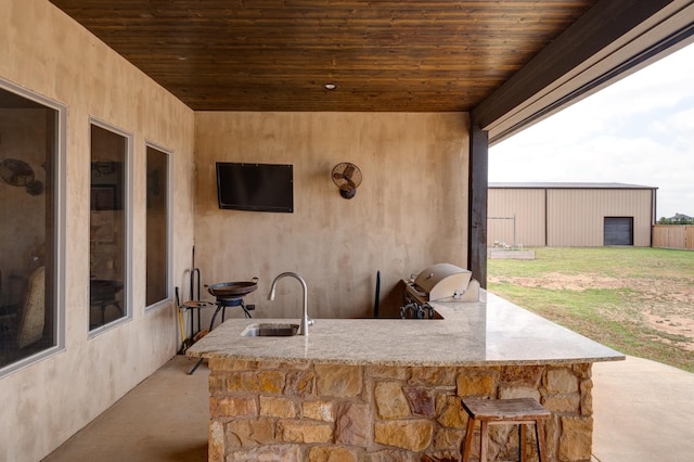 view of patio / terrace featuring a grill, a wet bar, and exterior kitchen