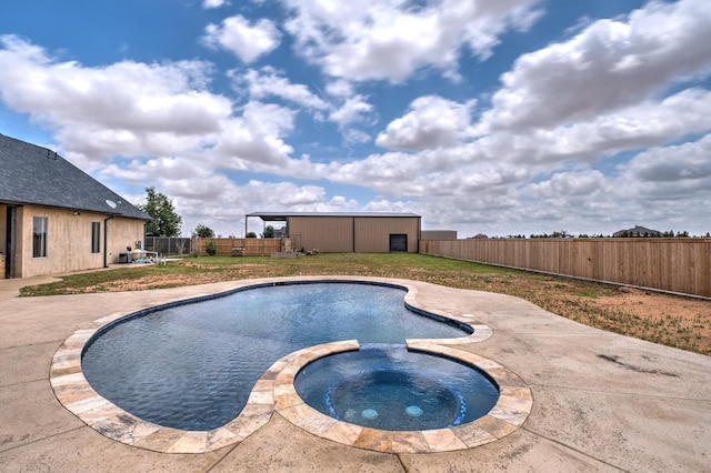 view of pool with an outbuilding, a lawn, and an in ground hot tub