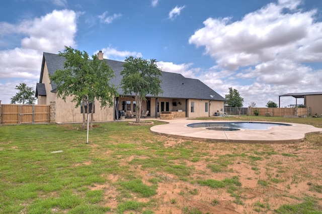 rear view of property with a yard, a fenced in pool, and a patio