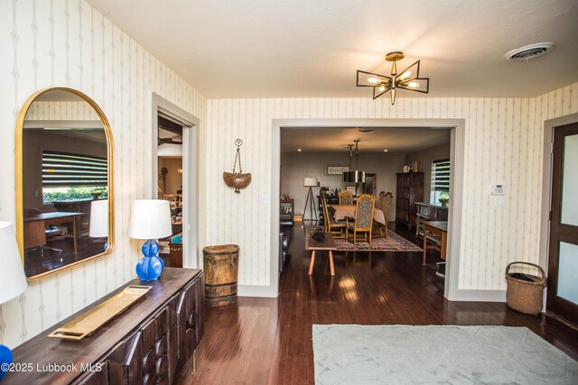 4609 10th St, Lubbock, TX 79416 - interior space featuring wallpapered walls, hardwood / wood-style flooring, a chandelier, and baseboards